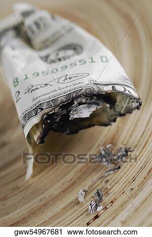 Stock Image - Close-up of burnt American paper currency. Fotosearch