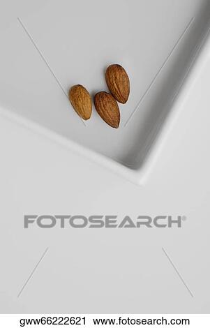 Close-up of three almonds on a tray View Large Photo Image Stock Image - Close-up of three almonds on a tray. Fotosearch