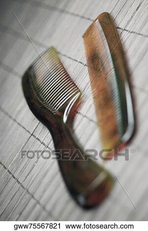 Stock Image - Close-up of two combs on a mat. Fotosearch