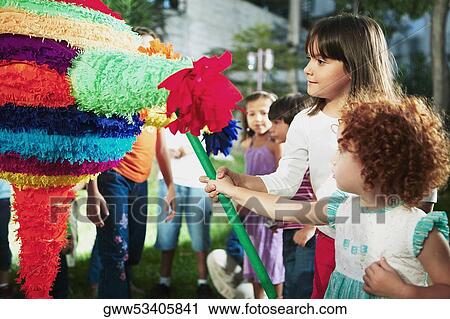 Close-up of two girls hitting a pinata with a stick View Large Photo Image Stock Image - Close-up of two girls hitting a pinata with a stick. Fotosearch