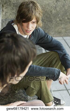 Close-up of two teenage boys sitting together View Large Photo Image Stock Image - Close-up of two teenage boys sitting together. Fotosearch