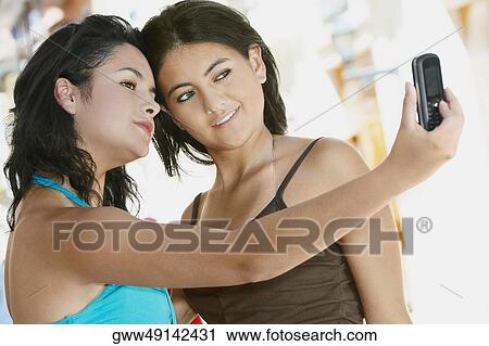 Close-up of two young women taking a photograph of themselves View Large Photo Image Stock Image - Close-up of two young women taking a photograph of themselves. Fotosearch