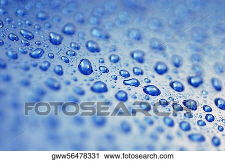 Stock Image - Close-up of water droplets on a blue surface. Fotosearch
