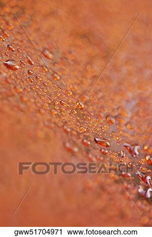 Stock Image - Close-up of water drops on a wet surface. Fotosearch