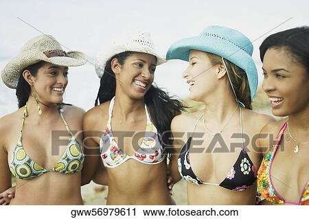 Four young women standing with their arms around each other on the beach View Large Photo Image Stock Image - Four young women standing with their arms around each other on the beach. Fotosearch