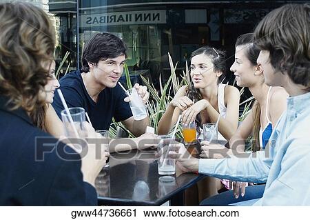 Group of people sitting together at a sidewalk cafe View Large Photo Image Stock Image - Group of people sitting together at a sidewalk cafe. Fotosearch