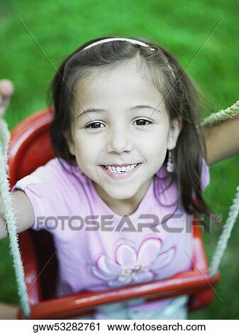 High angle view of a girl on a swing View Large Photo Image Stock Image - High angle view of a girl on a swing. Fotosearch