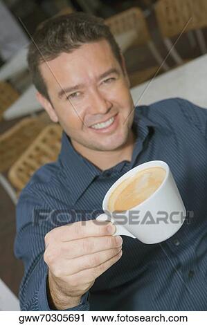 High angle view of a mid adult man holding a cup of tea in a restaurant View Large Photo Image Stock Image - High angle view of a mid adult man holding a cup of tea in a restaurant. Fotosearch