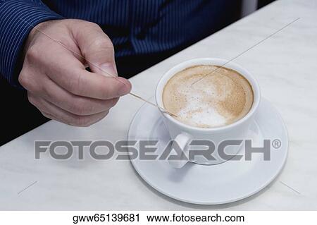 High angle view of a person's hand stirring tea View Large Photo Image Stock Image - High angle view of a person's hand stirring tea. Fotosearch