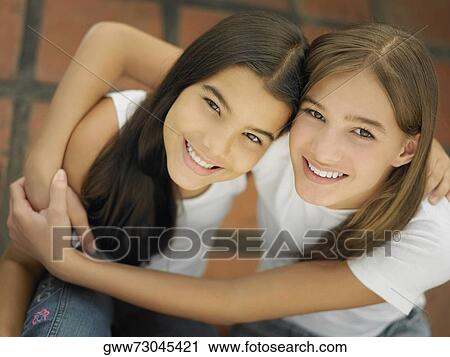 High angle view of a teenage girl hugging her sister View Large Photo Image Stock Image - High angle view of a teenage girl hugging her sister. Fotosearch