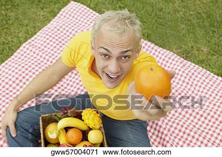 High angle view of a young man holding an orange View Large Photo Image Stock Image - High angle view of a young man holding an orange. Fotosearch