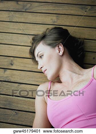 High angle view of a young woman lying on the hardwood floor View Large Photo Image Stock Image - High angle view of a young woman lying on the hardwood floor. Fotosearch