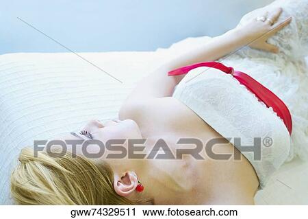 High angle view of a young woman lying on the bed View Large Photo Image Stock Image - High angle view of a young woman lying on the bed. Fotosearch