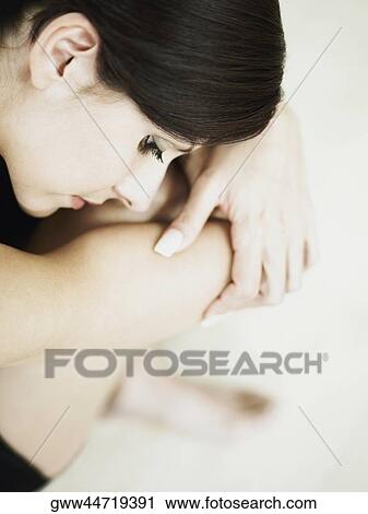 High angle view of a young woman sitting on the floor View Large Photo Image Stock Image - High angle view of a young woman sitting on the floor. Fotosearch