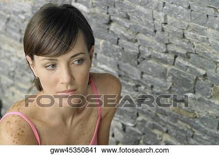 Stock Image - High angle view of a young woman looking serious. Fotosearch