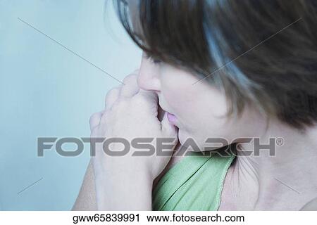 Stock Image - High angle view of a young woman hugging herself. Fotosearch