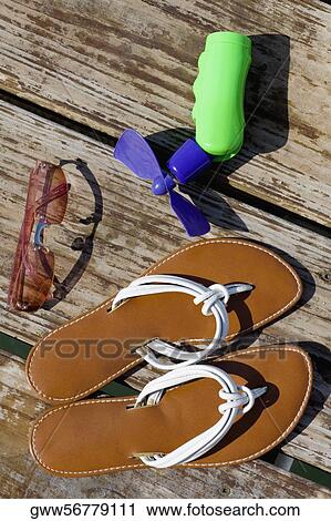 High angle view of sunglasses with slippers View Large Photo Image Stock Image - High angle view of sunglasses with slippers. Fotosearch