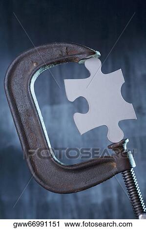 Jigsaw piece between the jaws of a clamp View Large Photo Image Stock Image - Jigsaw piece between the jaws of a clamp. Fotosearch