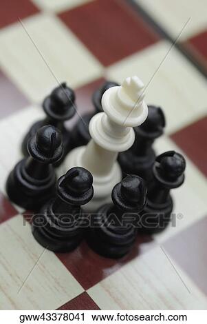 King chess piece surrounded by pawns on a chessboard View Large Photo Image Stock Image - King chess piece surrounded by pawns on a chessboard. Fotosearch