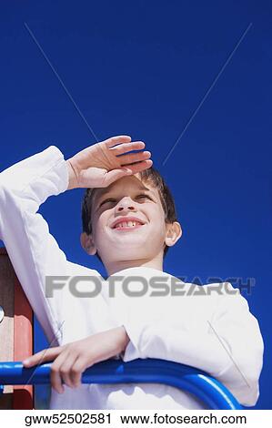 Low angle view of a boy on a jungle gym View Large Photo Image Stock Image - Low angle view of a boy on a jungle gym. Fotosearch