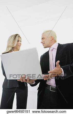 Low angle view of a businesswoman and a businessman using a laptop View Large Photo Image Stock Image - Low angle view of a businesswoman and a businessman using a laptop. Fotosearch
