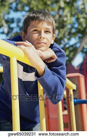 Low angle view of a teenage boy leaning on a railing and looking away View Large Photo Image Stock Image - Low angle view of a teenage boy leaning on a railing and looking away. Fotosearch