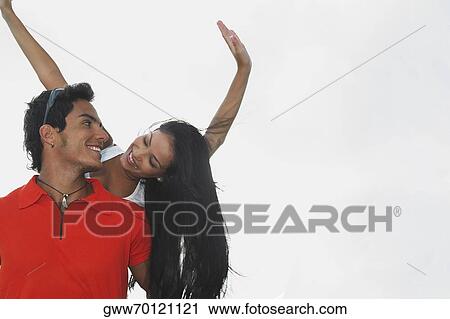 Low angle view of a young woman riding piggyback on a young man View Large Photo Image Stock Image - Low angle view of a young woman riding piggyback on a young man. Fotosearch