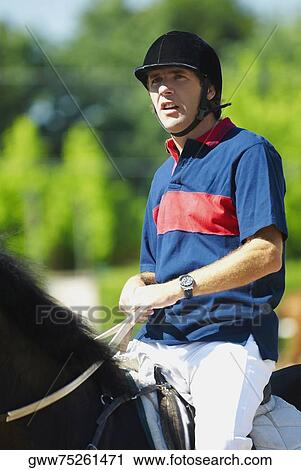 Mid adult man horseback riding View Large Photo Image Stock Image - Mid adult man horseback riding. Fotosearch
