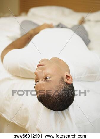 Mid adult man lying on the bed View Large Photo Image Stock Image - Mid adult man lying on the bed. Fotosearch