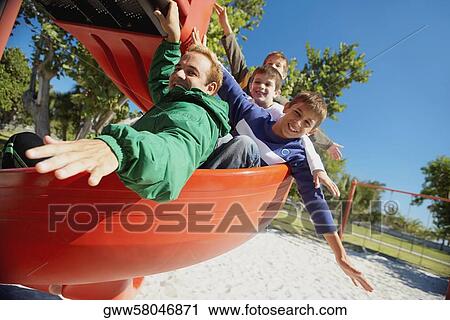 Mid adult man on a slide with three children View Large Photo Image Stock Image - Mid adult man on a slide with three children. Fotosearch
