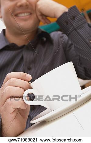 Mid adult man stirring tea View Large Photo Image Stock Image - Mid adult man stirring tea. Fotosearch