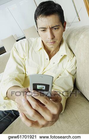 Mid adult man using a mobile phone View Large Photo Image Stock Image - Mid adult man using a mobile phone. Fotosearch