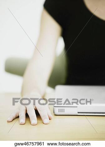 Mid section view of a businesswoman with a laptop on the desk View Large Photo Image Stock Image - Mid section view of a businesswoman with a laptop on the desk. Fotosearch