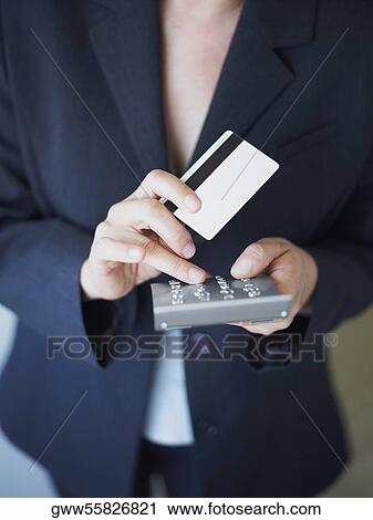 Mid section view of a businesswoman operating a calculator View Large Photo Image Stock Image - Mid section view of a businesswoman operating a calculator. Fotosearch