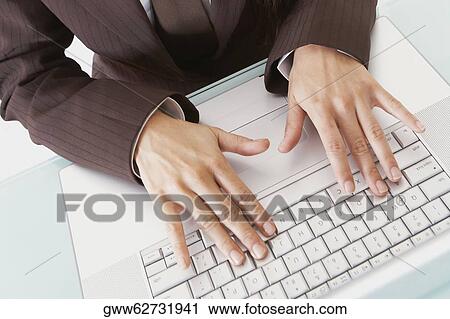 Mid section view of a businesswoman using a laptop View Large Photo Image Stock Image - Mid section view of a businesswoman using a laptop. Fotosearch