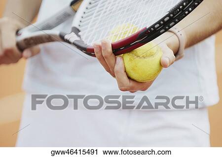 Mid section view of a female tennis player holding a tennis racket and a tennis ball View Large Photo Image Stock Image - Mid section view of a female tennis player holding a tennis racket and a tennis ball. Fotosearch