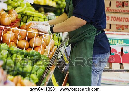 Mid section view of a grocer standing in a supermarket View Large Photo Image Stock Image - Mid section view of a grocer standing in a supermarket. Fotosearch