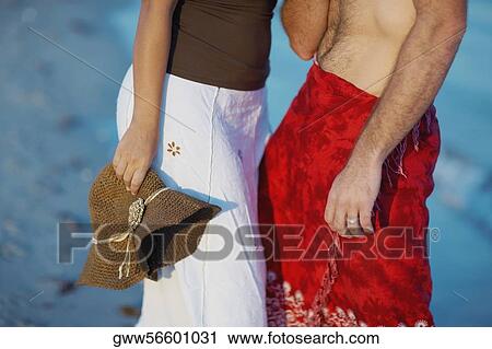 Mid section view of a man and a woman standing on the beach View Large Photo Image Stock Image - Mid section view of a man and a woman standing on the beach. Fotosearch