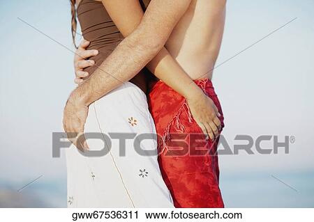 Mid section view of a man and a woman embracing each other View Large Photo Image Stock Image - Mid section view of a man and a woman embracing each other. Fotosearch