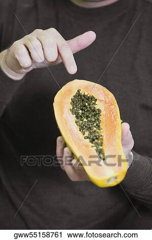 Mid section view of a man holding one half of a papaya View Large Photo Image Stock Image - Mid section view of a man holding one half of a papaya. Fotosearch
