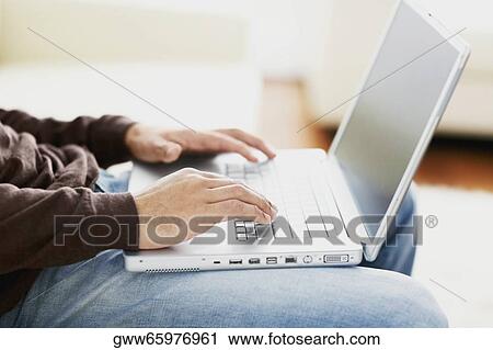Mid section view of a man using a laptop View Large Photo Image Stock Image - Mid section view of a man using a laptop. Fotosearch