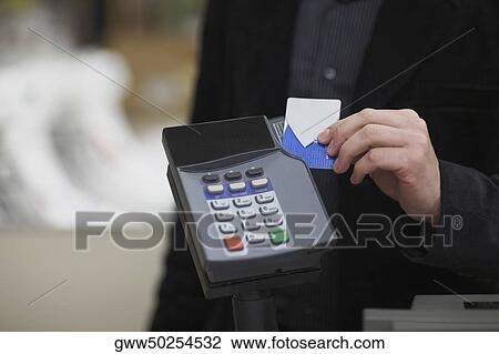 Mid section view of a man using a credit card reader View Large Photo Image Stock Image - Mid section view of a man using a credit card reader. Fotosearch