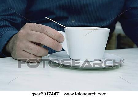 Mid section view of a person holding a tea cup View Large Photo Image Stock Image - Mid section view of a person holding a tea cup. Fotosearch