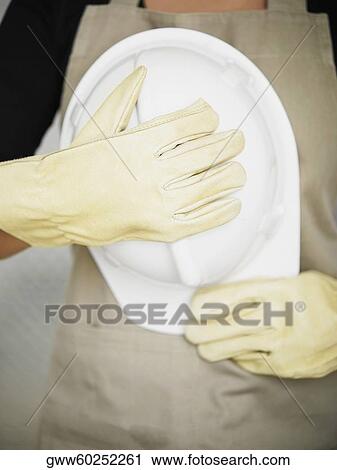 Mid section view of a person holding a hardhat View Large Photo Image Stock Image - Mid section view of a person holding a hardhat. Fotosearch