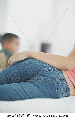 Mid section view of a woman lying down on the bed View Large Photo Image Stock Image - Mid section view of a woman lying down on the bed. Fotosearch