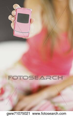 Mid section view of a woman showing a mobile phone View Large Photo Image Stock Image - Mid section view of a woman showing a mobile phone. Fotosearch