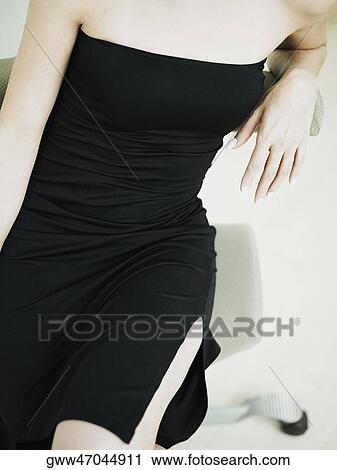 Mid section view of a woman sitting View Large Photo Image Stock Image - Mid section view of a woman sitting. Fotosearch