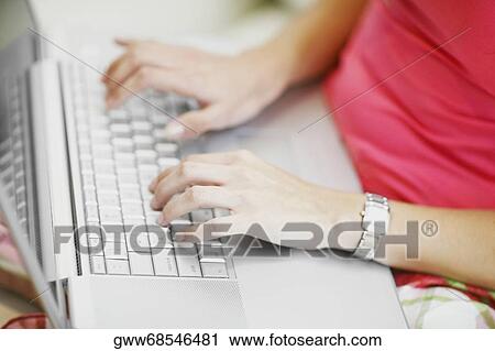 Mid section view of a woman using a laptop View Large Photo Image Stock Image - Mid section view of a woman using a laptop. Fotosearch