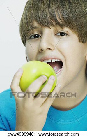 Portrait of a boy eating an apple View Large Photo Image Stock Image - Portrait of a boy eating an apple. Fotosearch