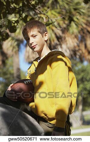 Stock Image - Portrait of a boy holding a football. Fotosearch